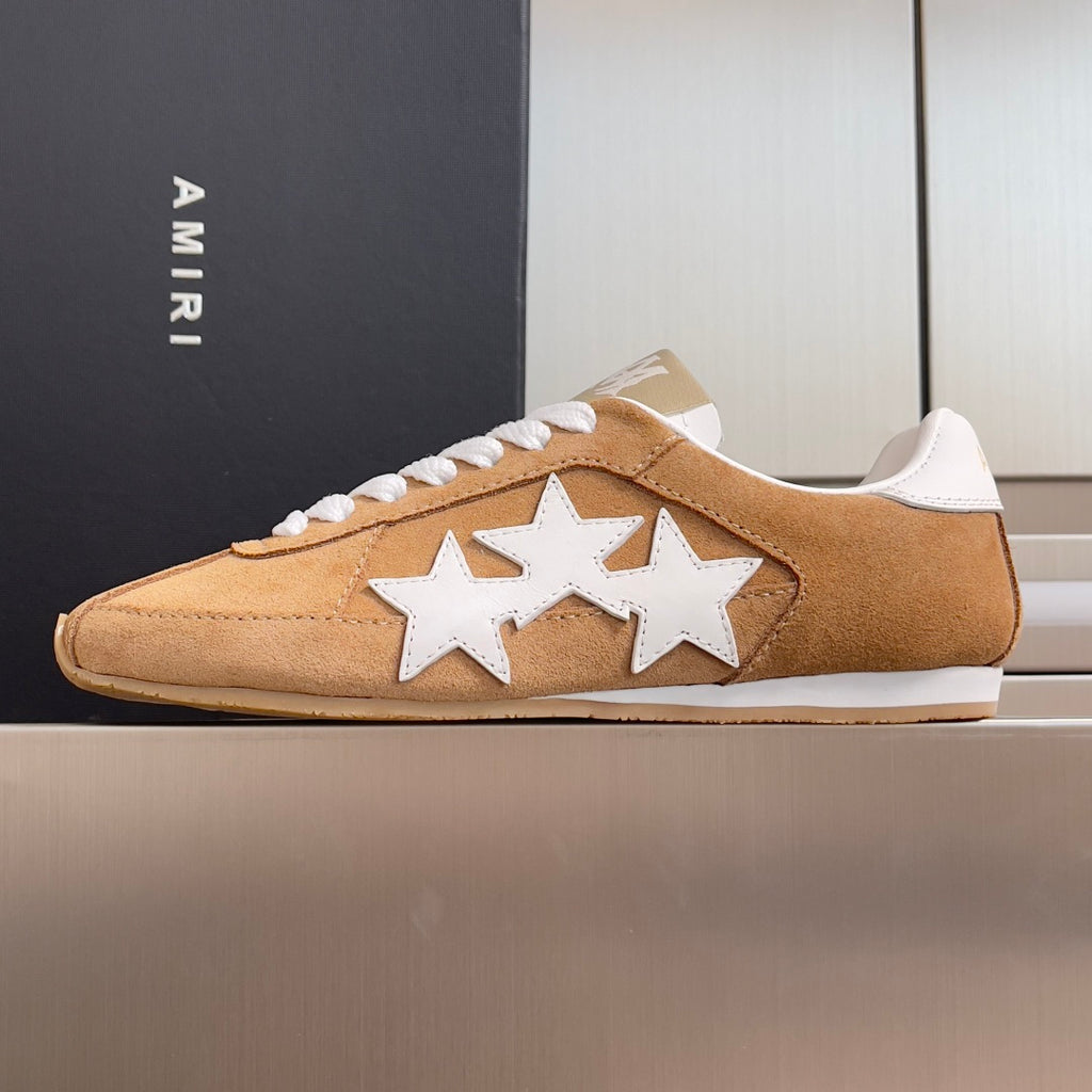 Tan suede sneakers with white star appliques and white lace-up front