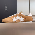Tan suede sneakers with white star appliques and white lace-up front