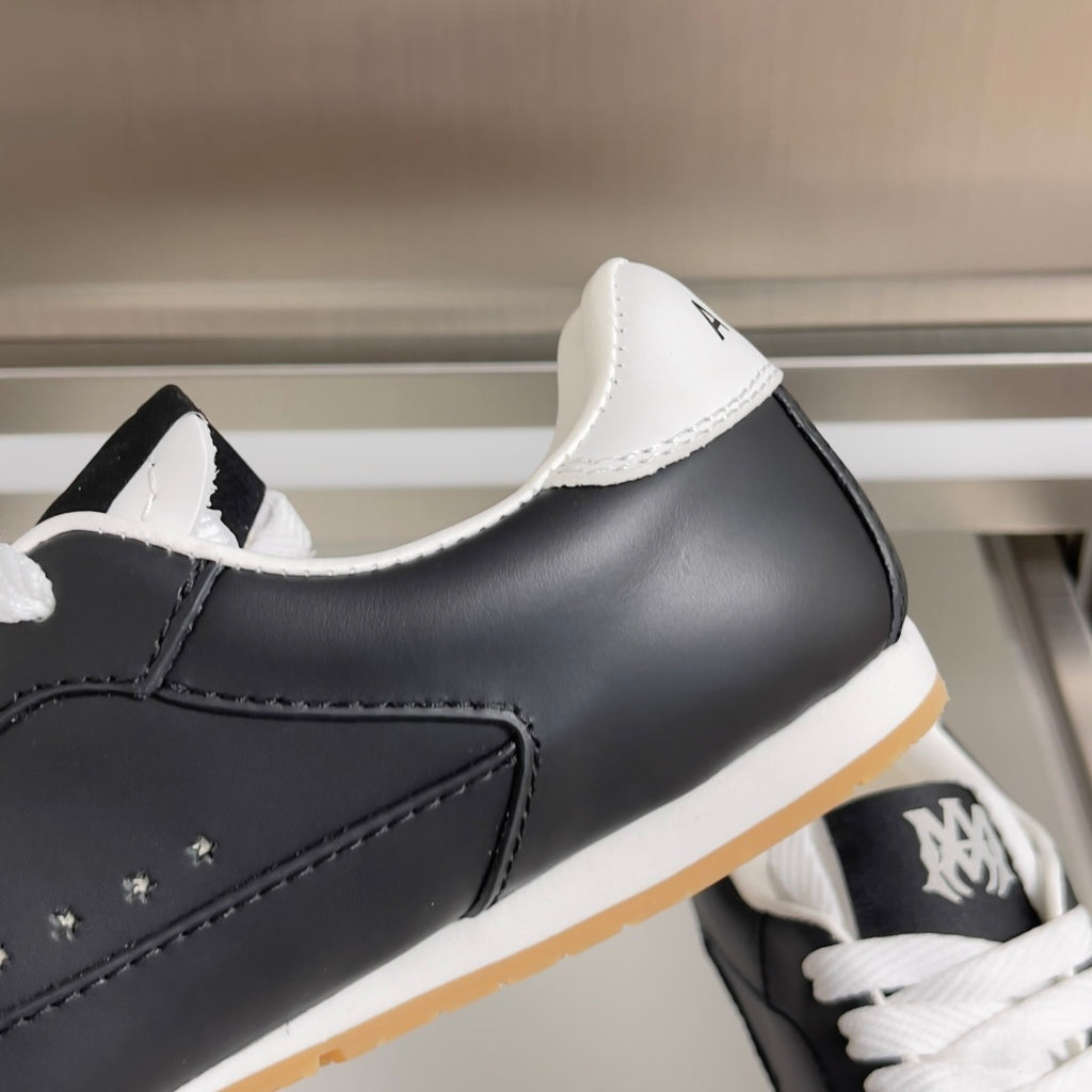 Close-up of black leather sneaker with white star patch and white laces
