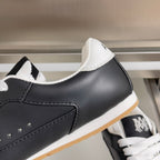 Close-up of black leather sneaker with white star patch and white laces