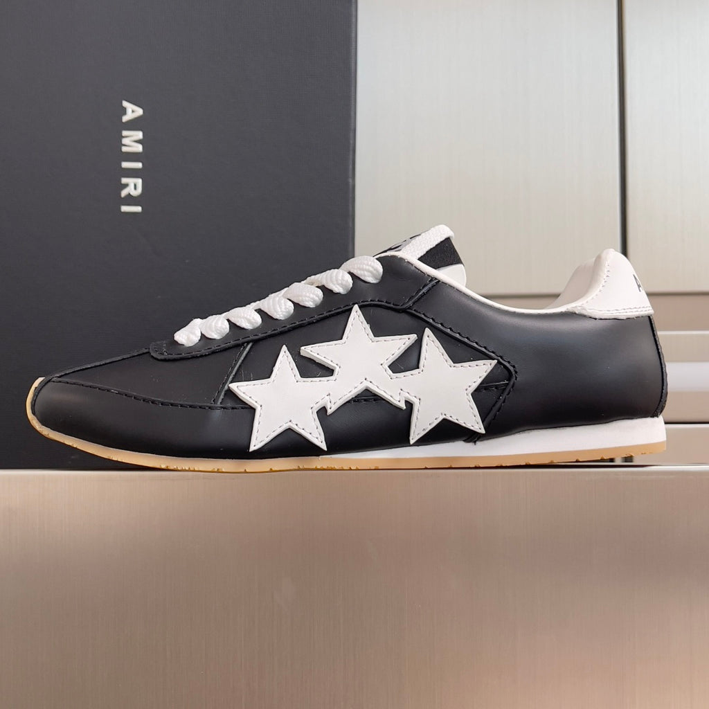Black leather sneaker with white star detail, white laces, and gum outsole