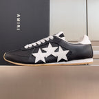 Black leather sneaker with white star detail, white laces, and gum outsole
