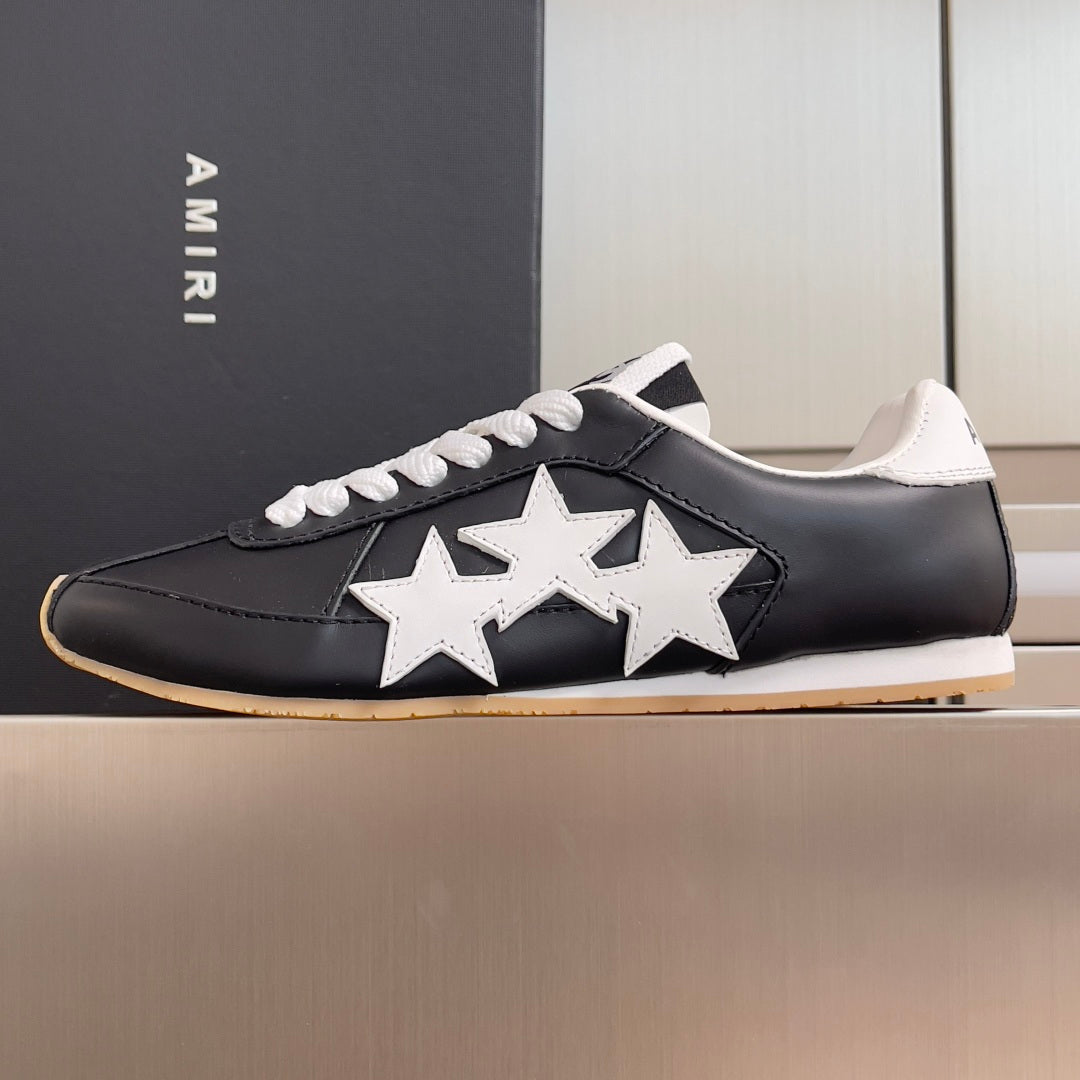 Black leather sneaker with white star detail, white laces, and gum outsole