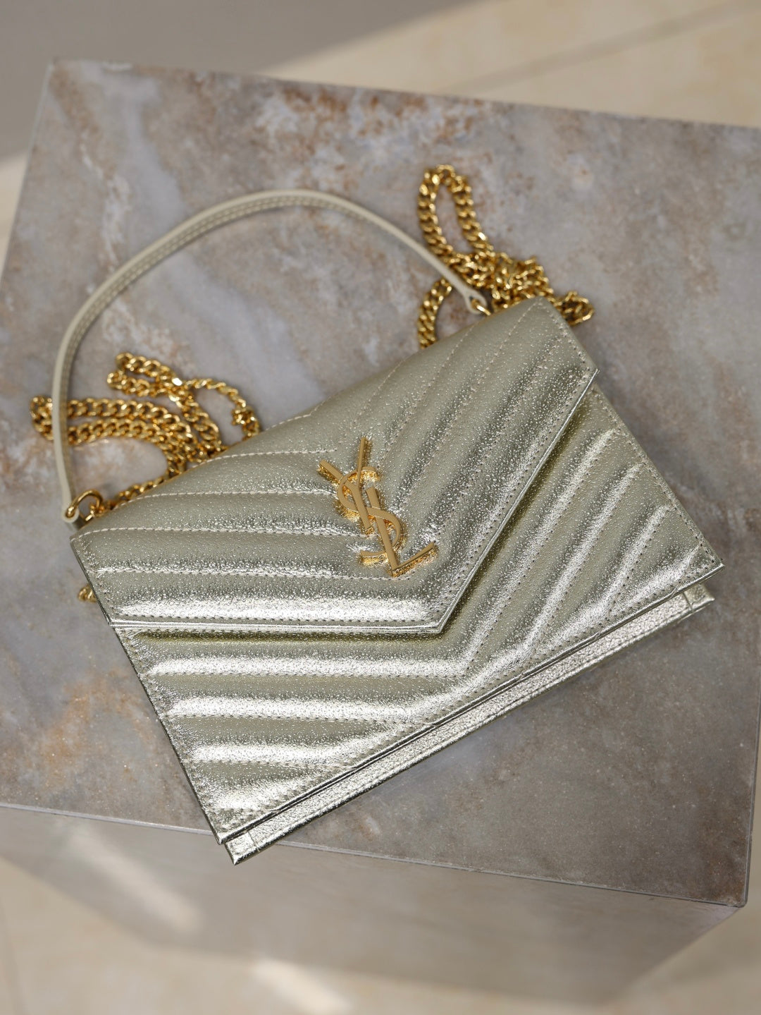 YSL metallic gold mini flap bag with chain strap and YSL logo on chevron quilting