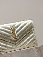 YSL metallic gold flap bag close-up with YSL logo on chevron quilting