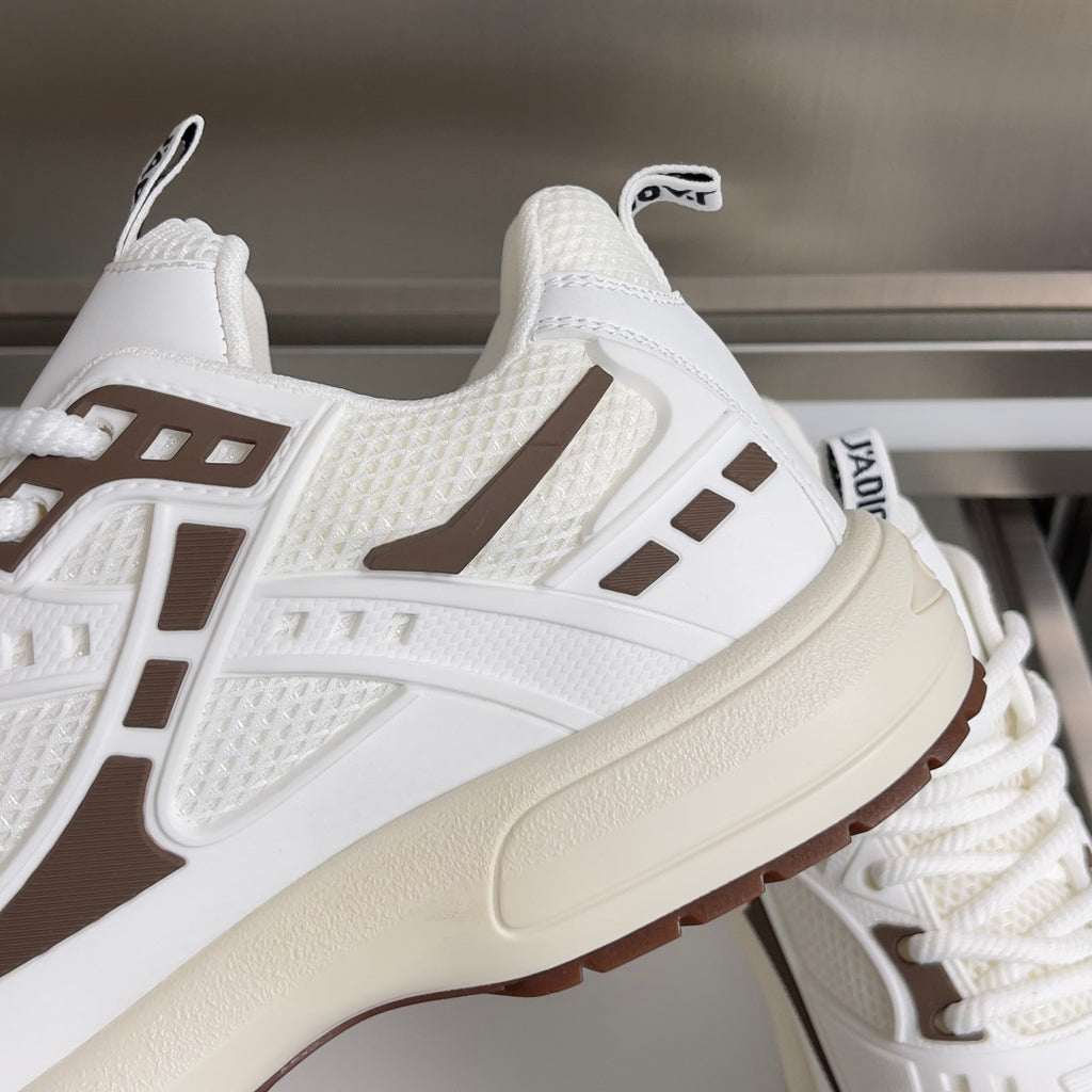 Dior unisex sneaker close-up, white textured upper with brown side stripe and thick sole