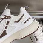 Dior unisex sneaker close-up, white textured upper with brown side stripe and thick sole