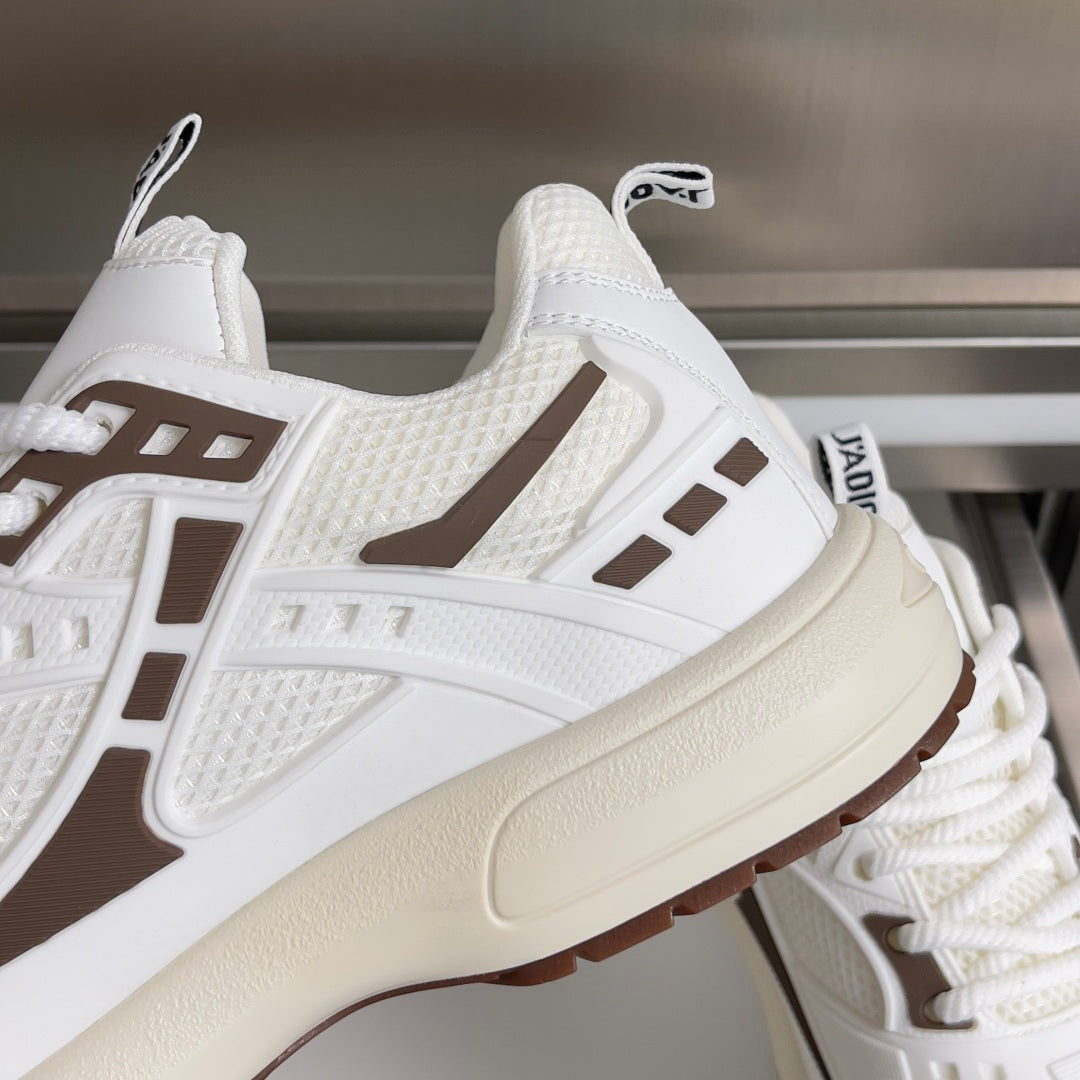 Dior unisex sneaker close-up, white textured upper with brown side stripe and thick sole