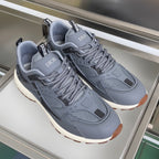 Pair of unisex Dior lace-up sneakers in blue-gray with chunky off-white sole.