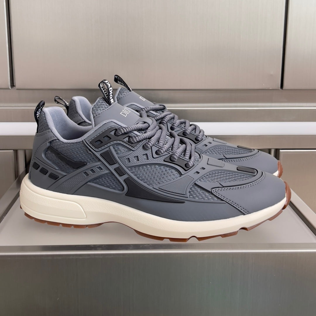 Unisex Dior sneakers in light blue-gray with lace-up front and cushioned sole.