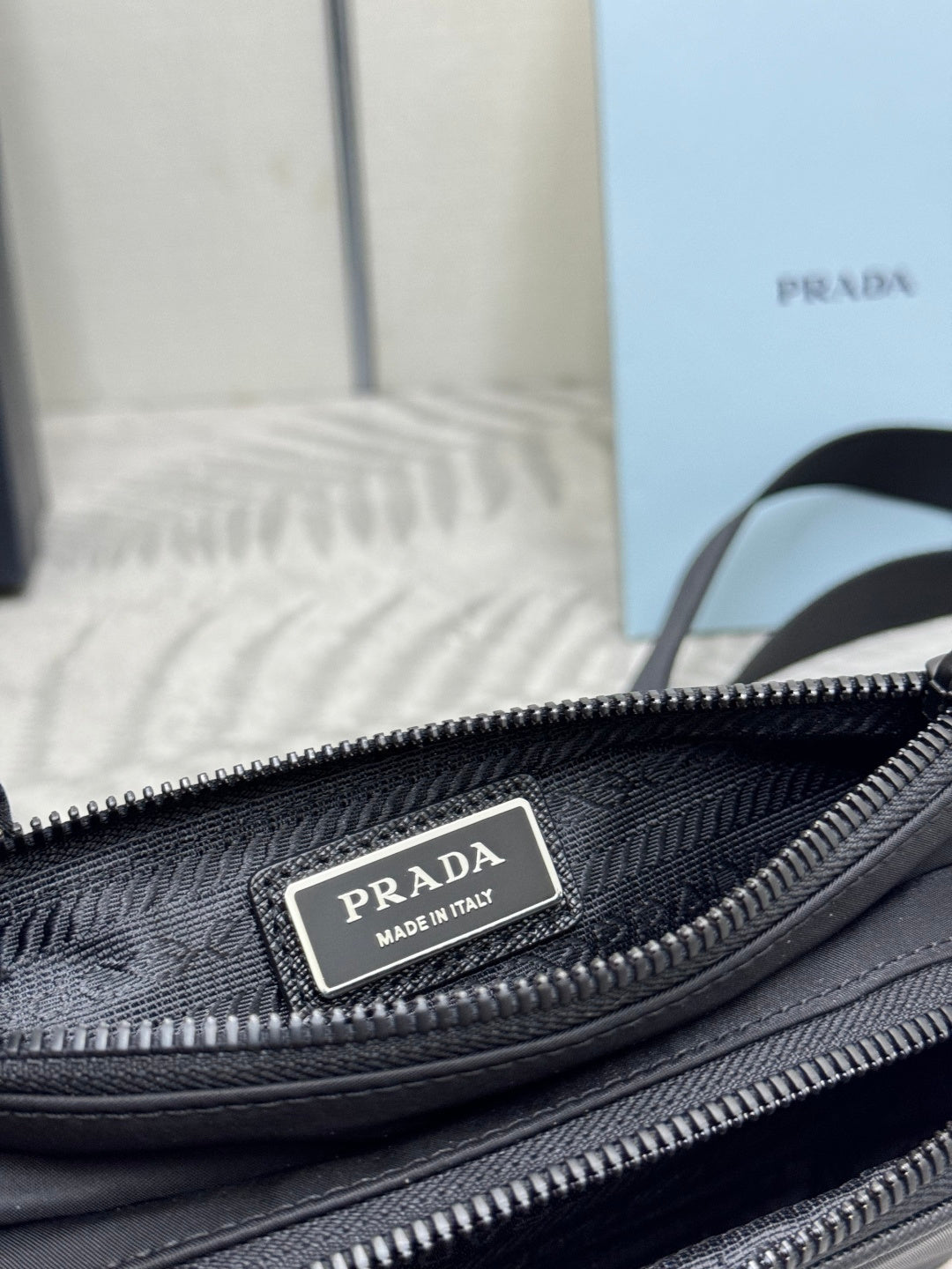 Black Prada bag close-up of inner logo label on zipper track and lining texture.