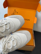 Close view of white sneaker toe and laces with multicolor logo trim on side