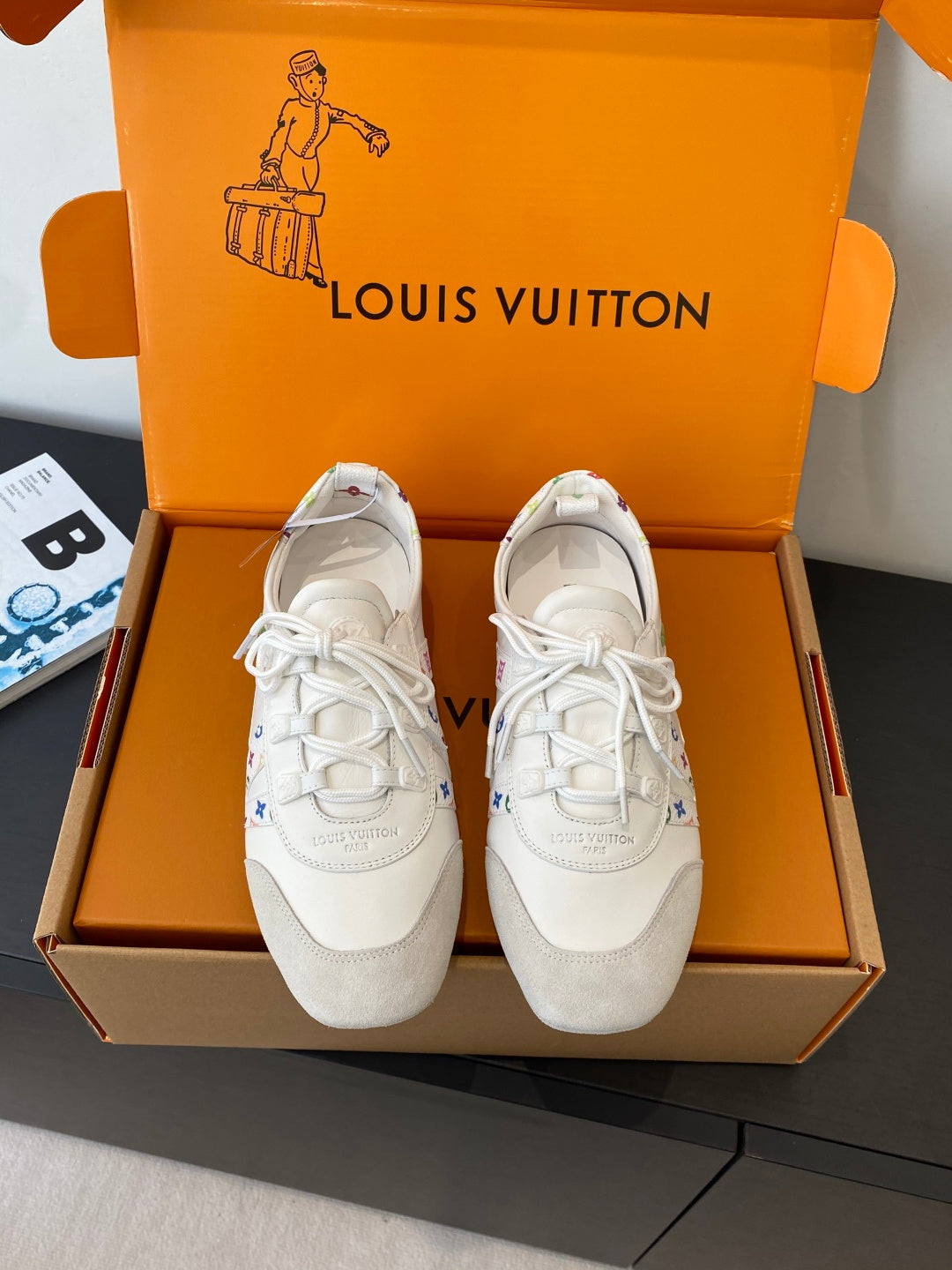 White unisex sneakers with white laces, shown in an open shoebox