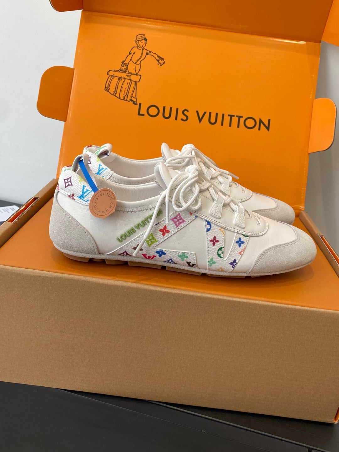 White unisex sneakers with multicolor patterned side panels and white lace-up closure
