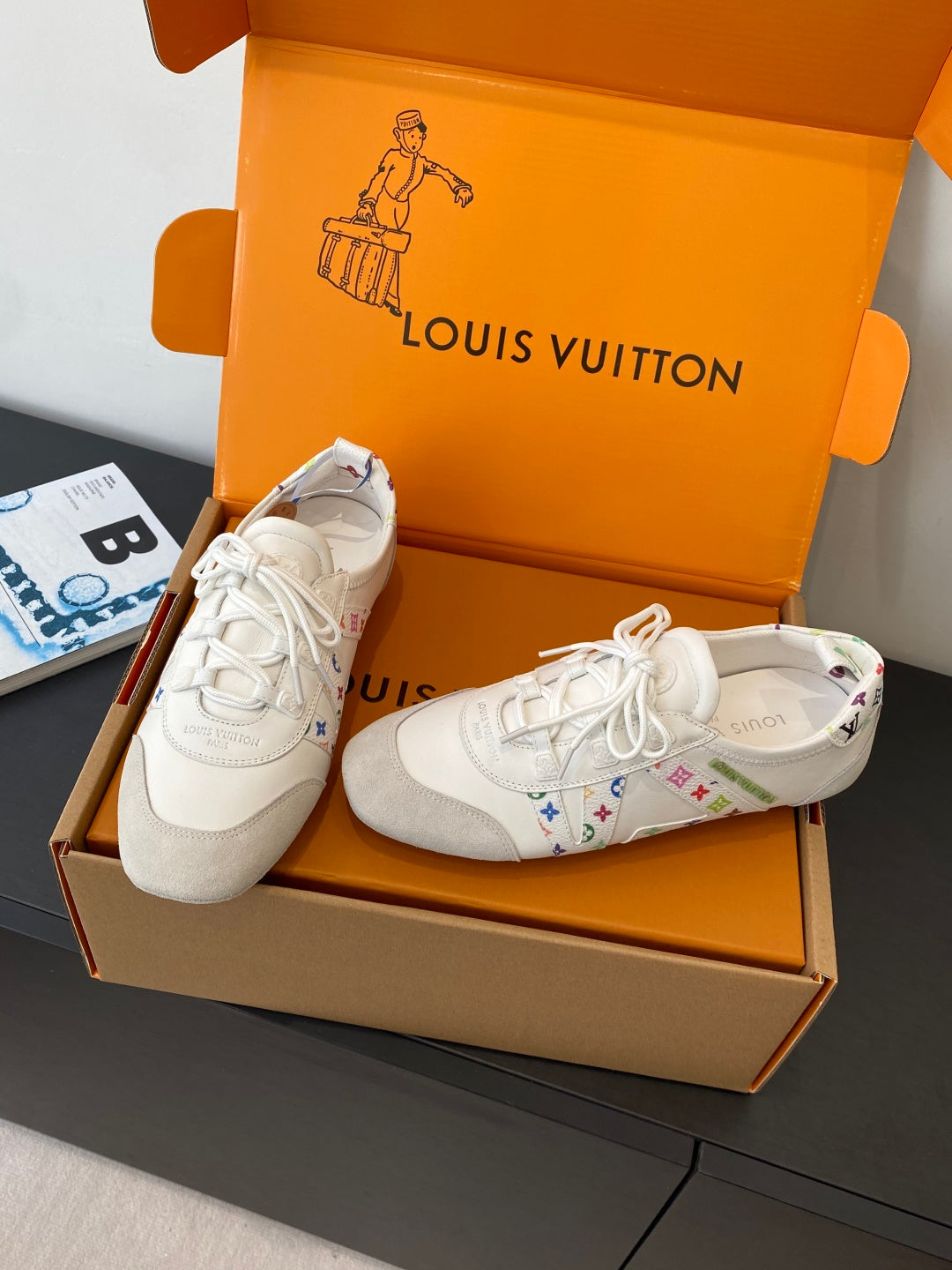 White unisex sneakers with white laces and multicolor side logo detail in shoebox