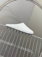 White slide sandal on wire rack with curved toe profile