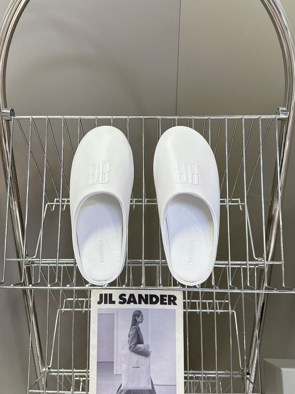 Pair of white slide sandals with embossed logo on top