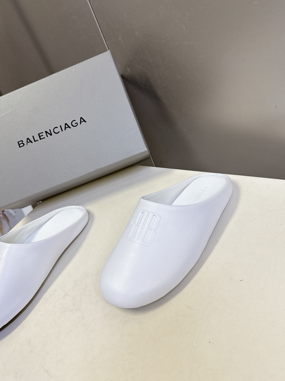 White slide sandals, pair view with embossed logo on upper