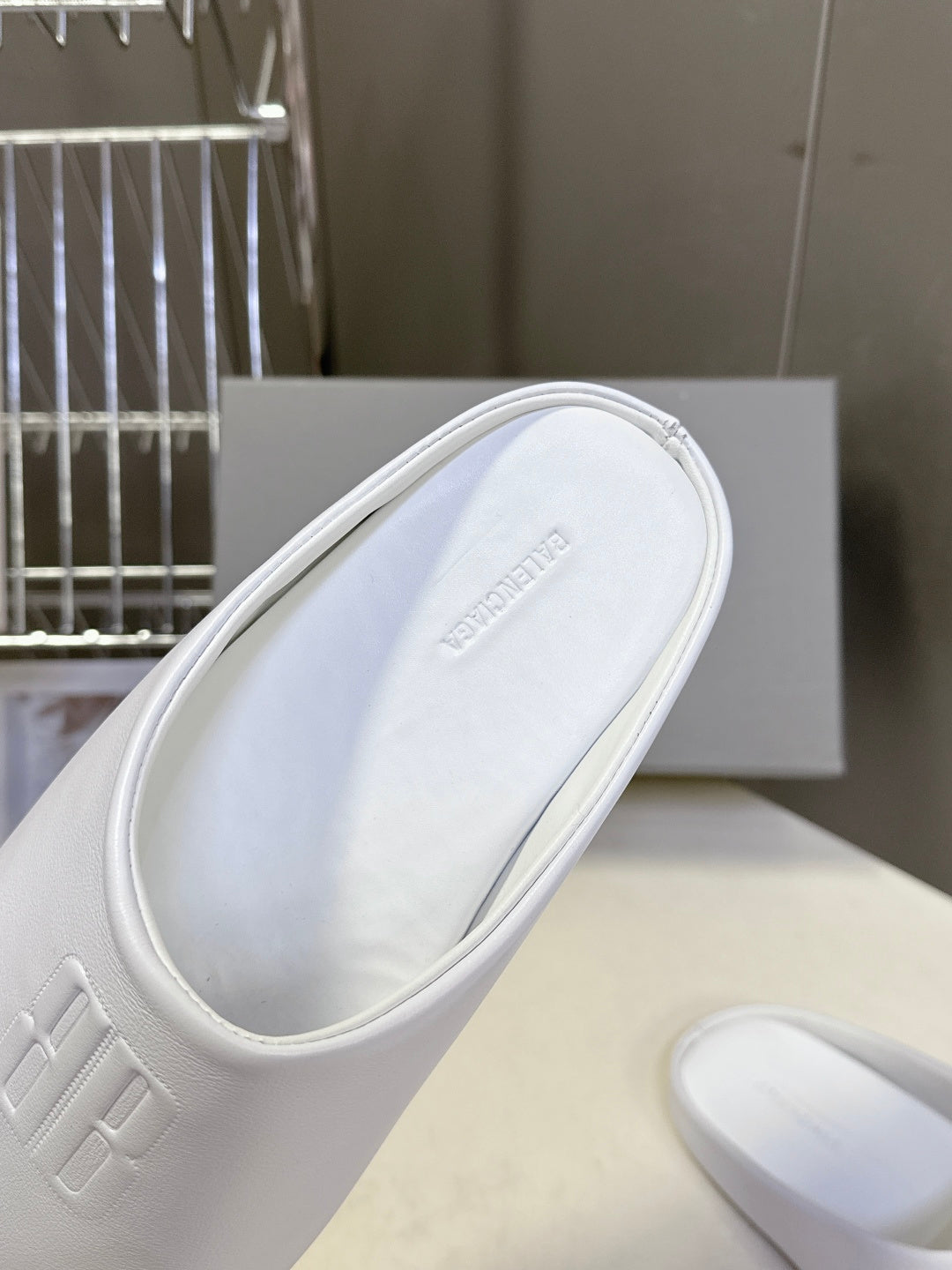 White slide sandal showing insole and embossed brand mark