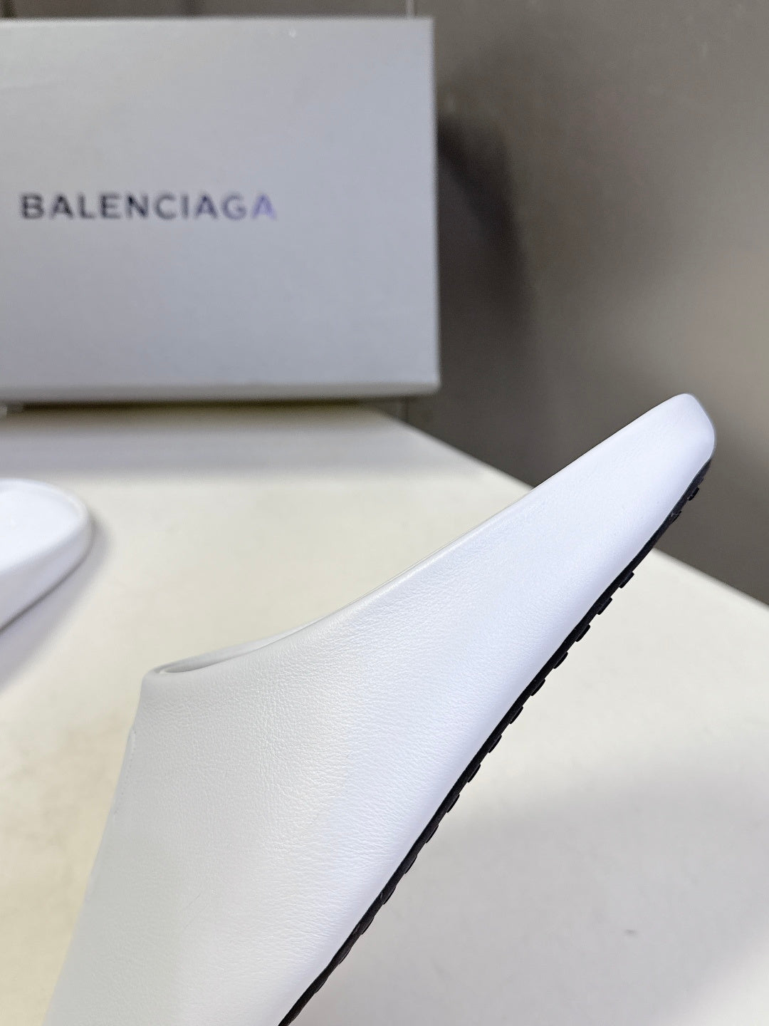 White slide sandal with smooth upper and thick sole edge