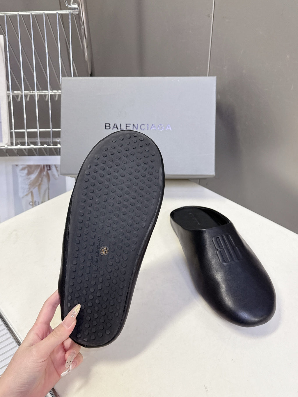 Balenciaga black slide sandal outsole with textured tread, pair view