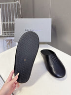 Balenciaga black slide sandal outsole with textured tread, pair view