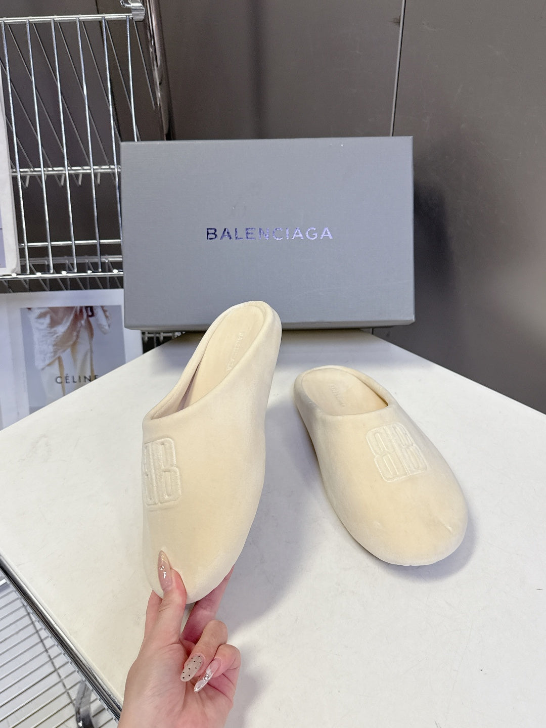 Balenciaga slide sandals, light beige, held front view with embossed logo