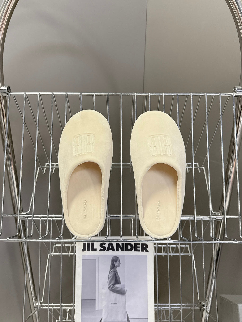 Balenciaga slide sandals, light beige, pair front view with embossed logo footbed
