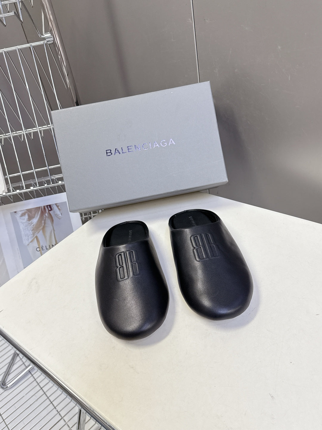 Balenciaga black leather slide sandals with embossed logo on strap, pair
