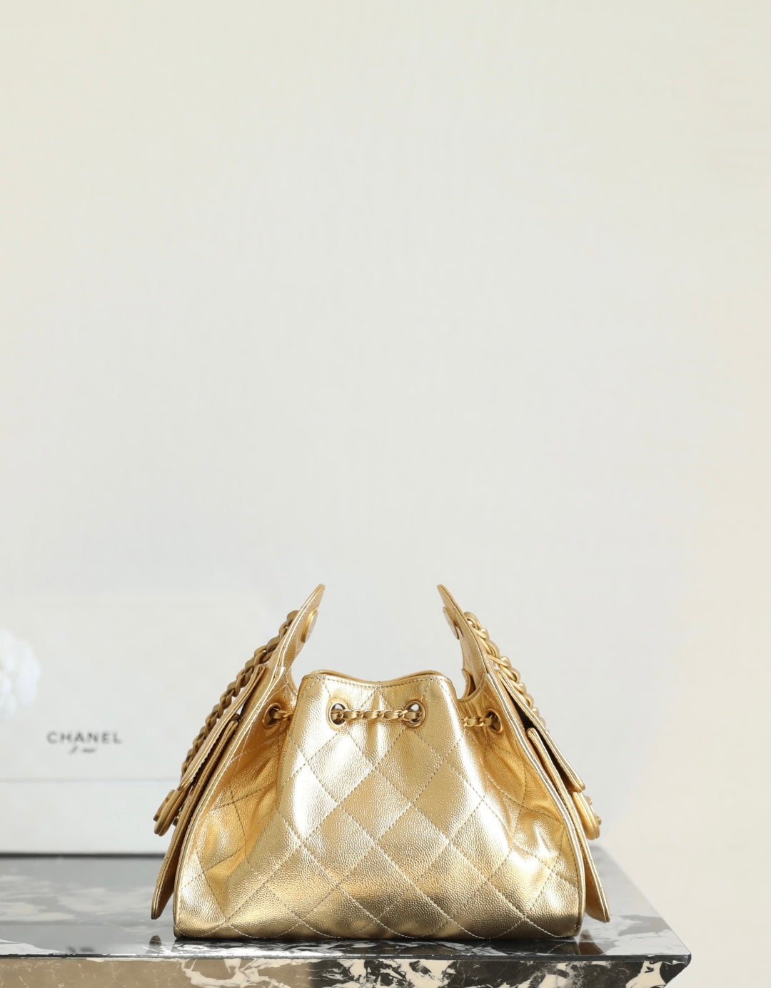 Chanel metallic-gold quilted bucket bag with chain straps and gold clasp