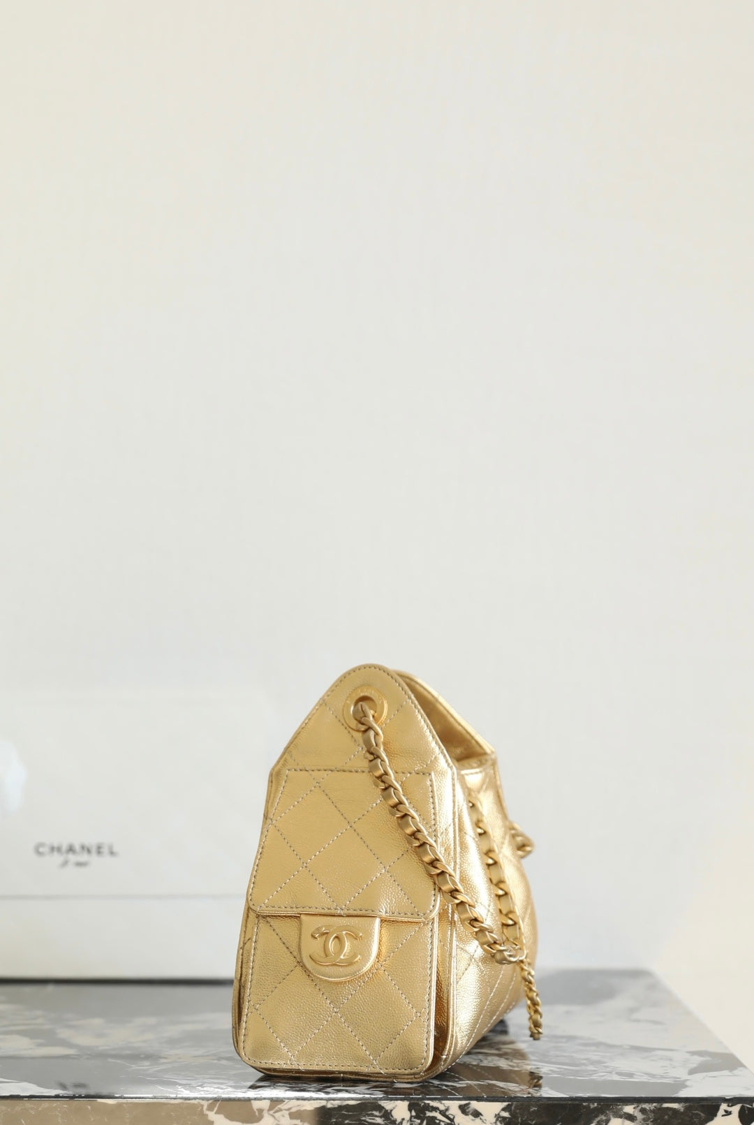 Chanel metallic-gold quilted bucket bag with chain strap and gold logo plate