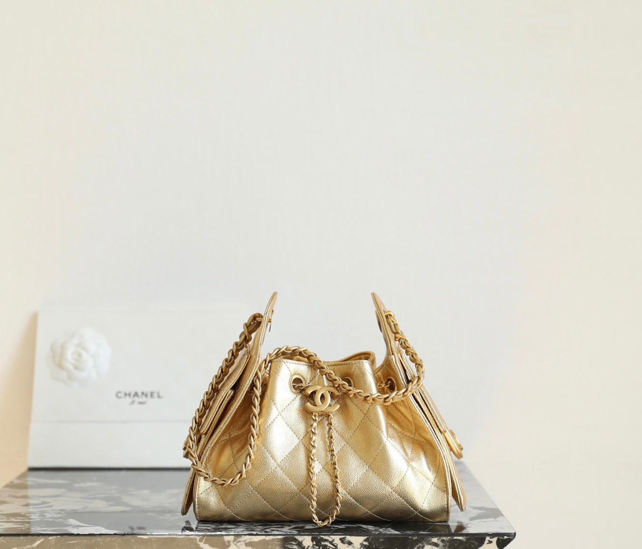 Chanel quilted metallic-gold bucket bag with chain straps and drawstring closure
