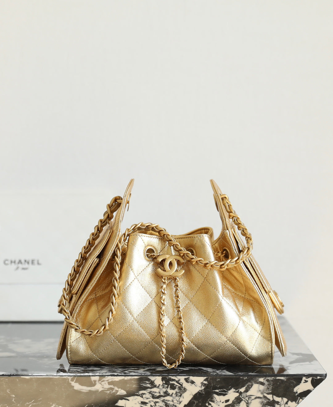 Chanel quilted metallic-gold bucket bag with chain straps and CC front detail