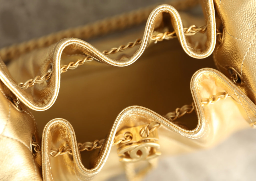 Chanel metallic-gold bag interior with chain hardware and zipper pull