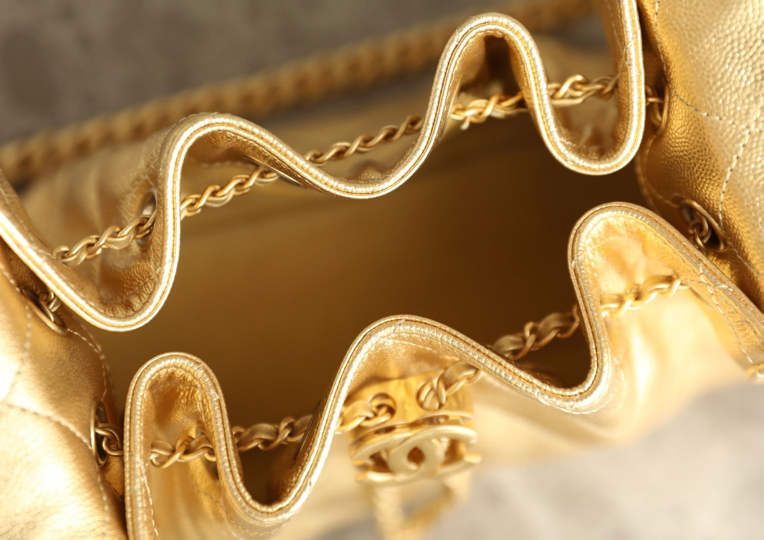 Chanel metallic-gold bag interior with chain hardware and zipper pull