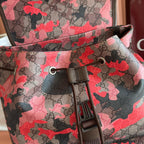 Gucci backpack front close-up with camo GG canvas, buckle, and zipper pull tabs