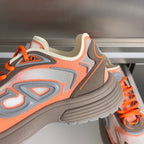 Dior unisex sneaker close-up, orange laces, ribbed sole and graphic stitched panels
