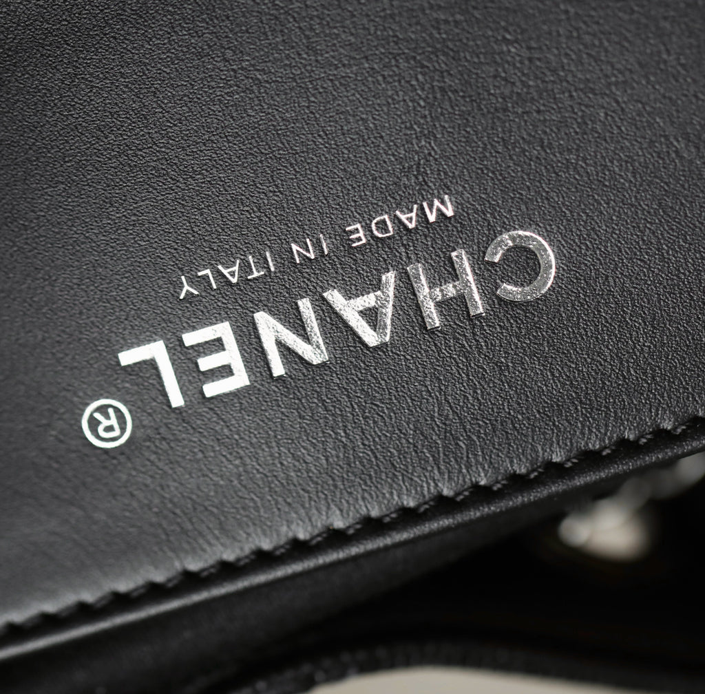 Black leather label close-up with "CHANEL" text and "MADE IN ITALY"
