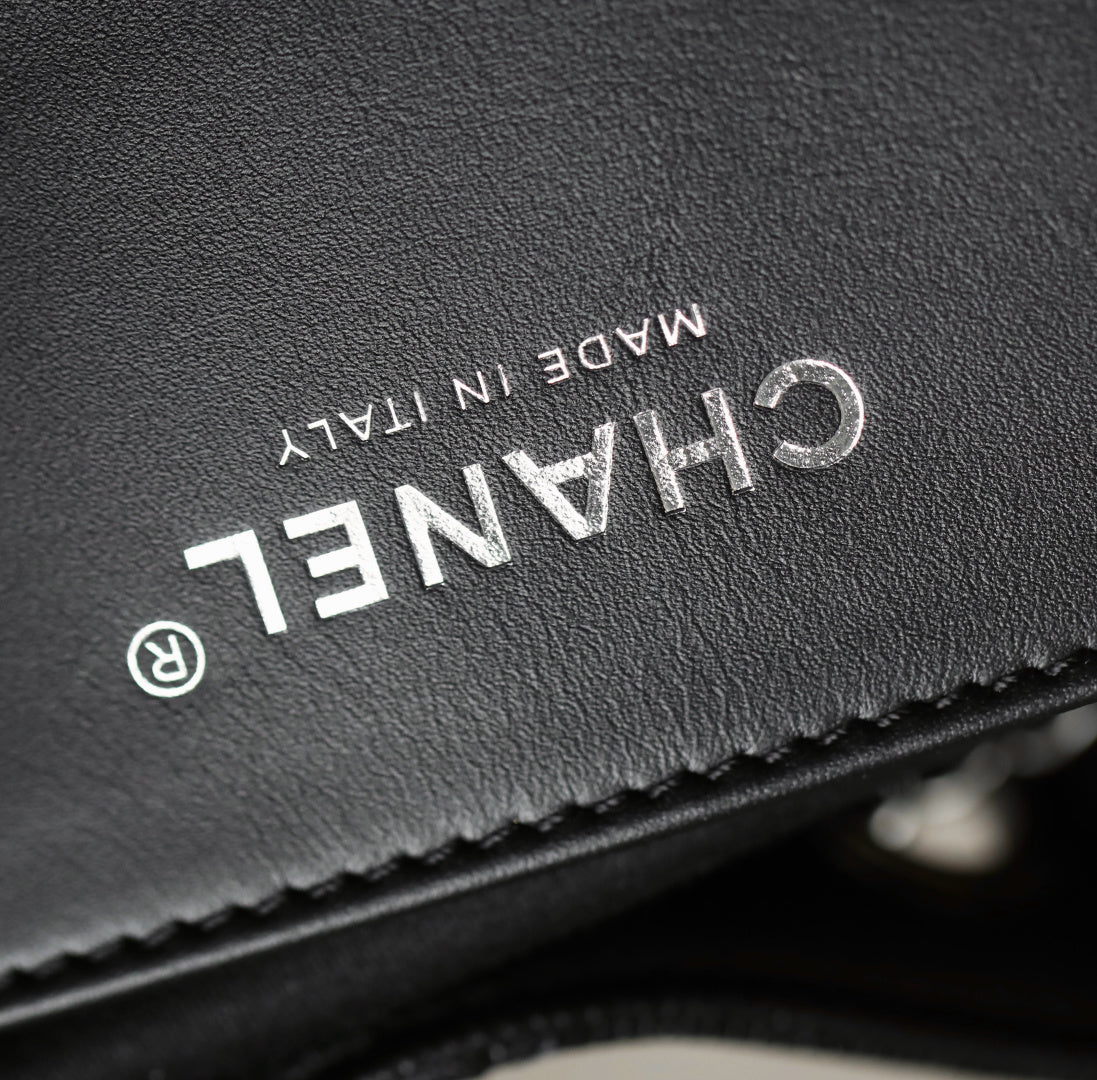 Black leather label close-up with "CHANEL" text and "MADE IN ITALY"