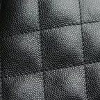 Black pebbled leather texture close-up with stitched panel seams