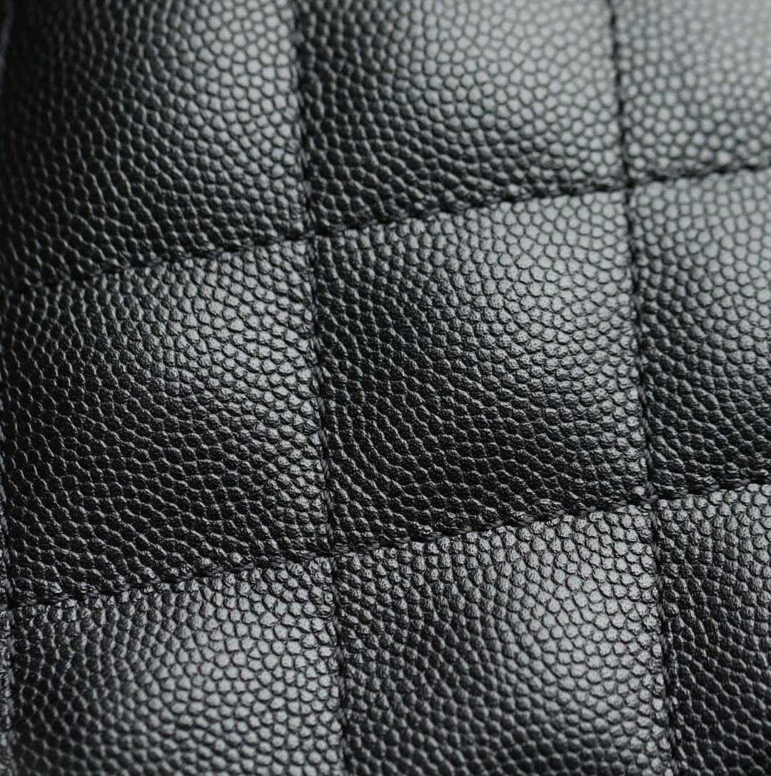 Black pebbled leather texture close-up with stitched panel seams
