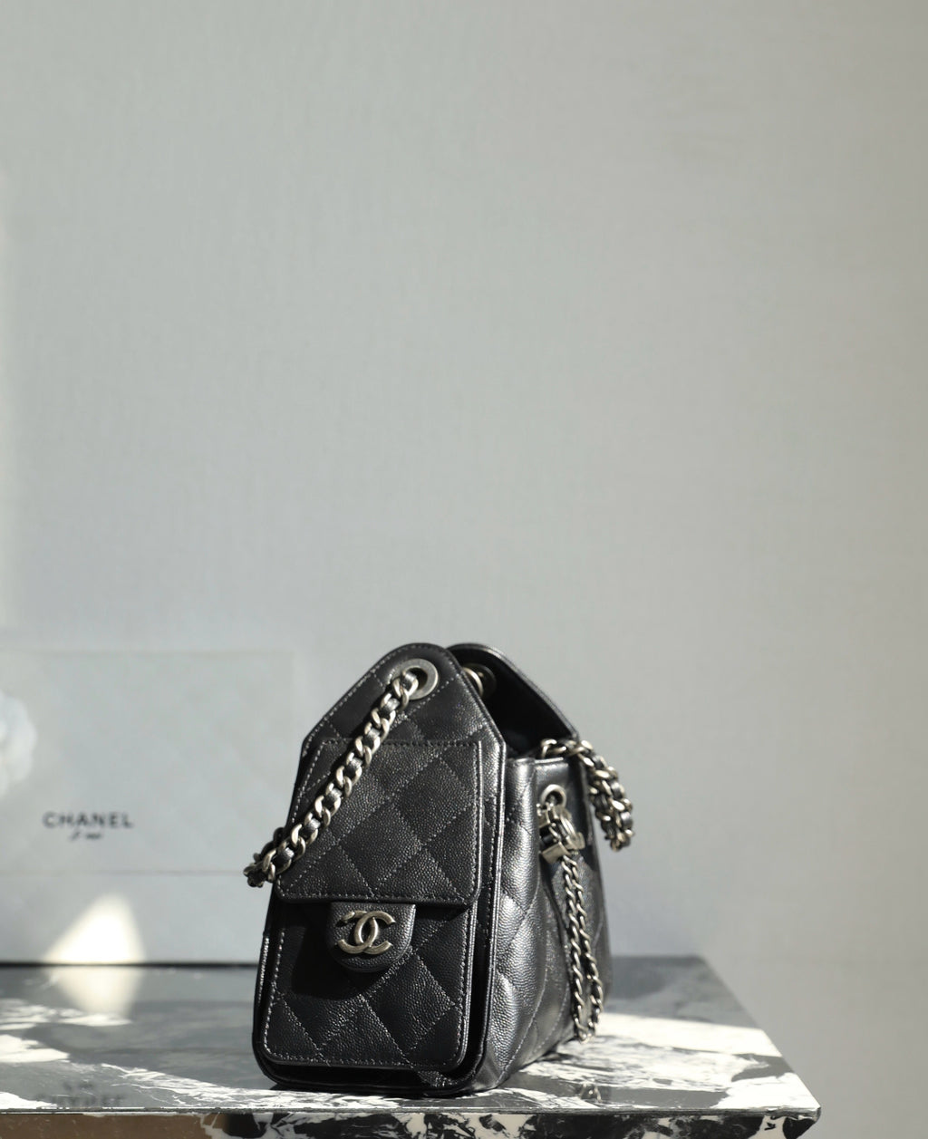 Black quilted mini flap bag with chain strap and CC logo hardware on front