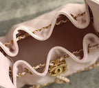Pink Chanel bag interior with stitched edge and gold chain hardware detail