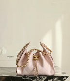 Pink Chanel drawstring bag with gold chain straps and quilted front panel
