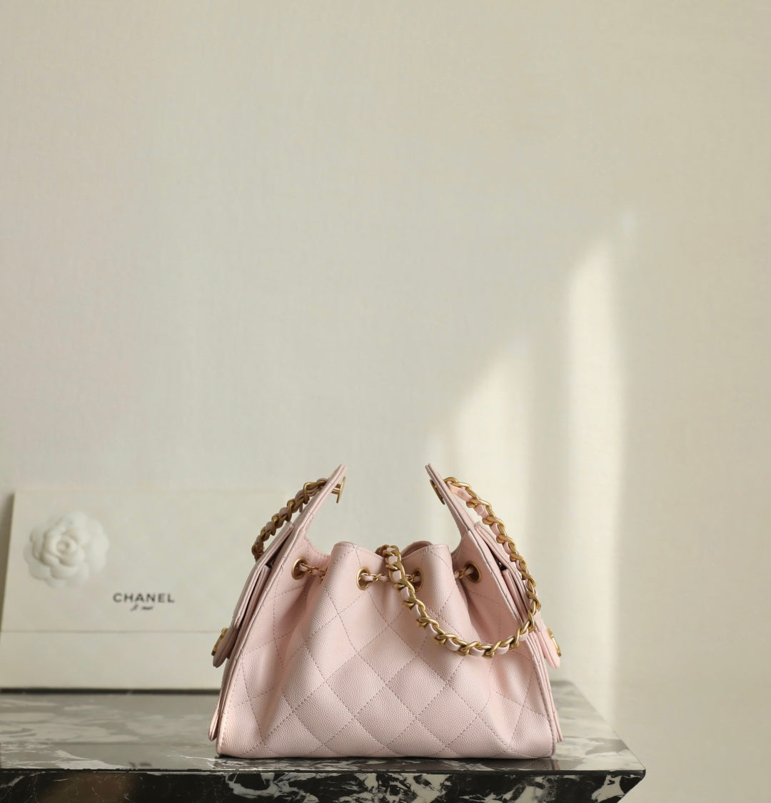 Pink Chanel drawstring bag with gold chain straps and diamond-quilt pattern