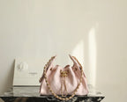Pink Chanel drawstring bag with gold chain and central clasp, quilted panels