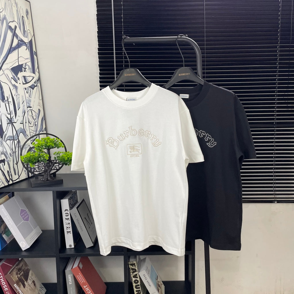 White and black short-sleeve T-shirts on hangers with Burberry logo on front.