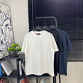 Short-sleeve T-shirt display: white tee on hanger among dark tees