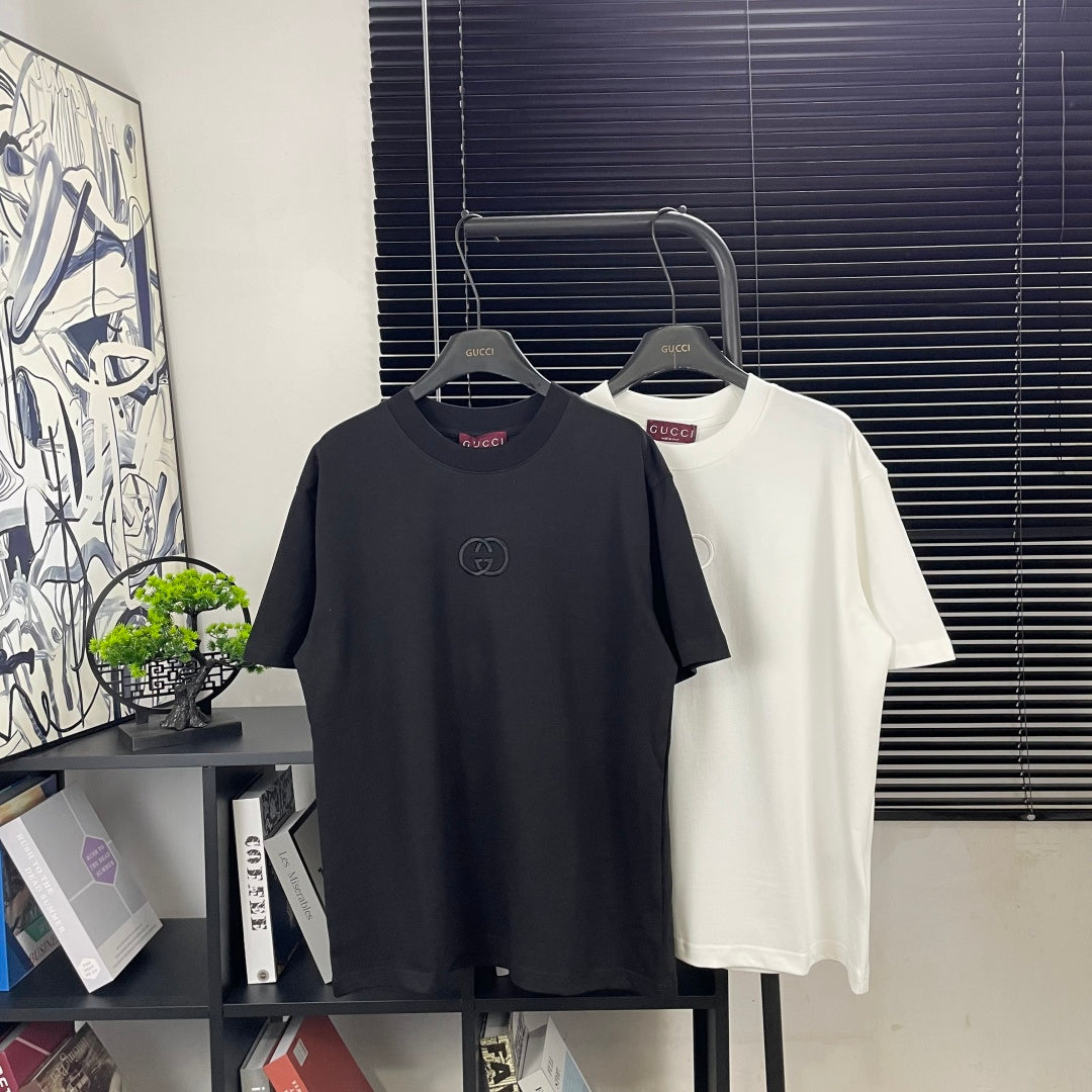 Black and white short-sleeve T-shirts on hangers, Gucci logos at chest