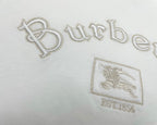 White T-shirt close-up with jeweled-style Burberry wordmark and crest